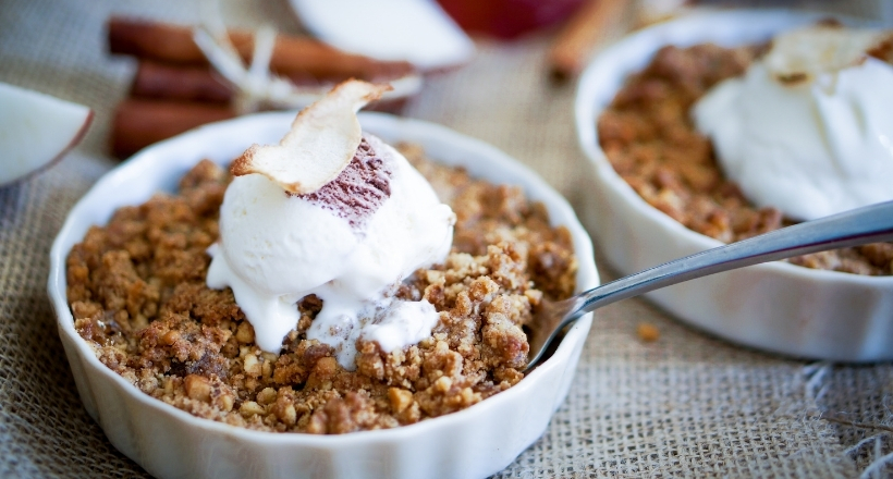 Dessert mit Apfel-Crumble und Vanilleeis serviert in einer Schale