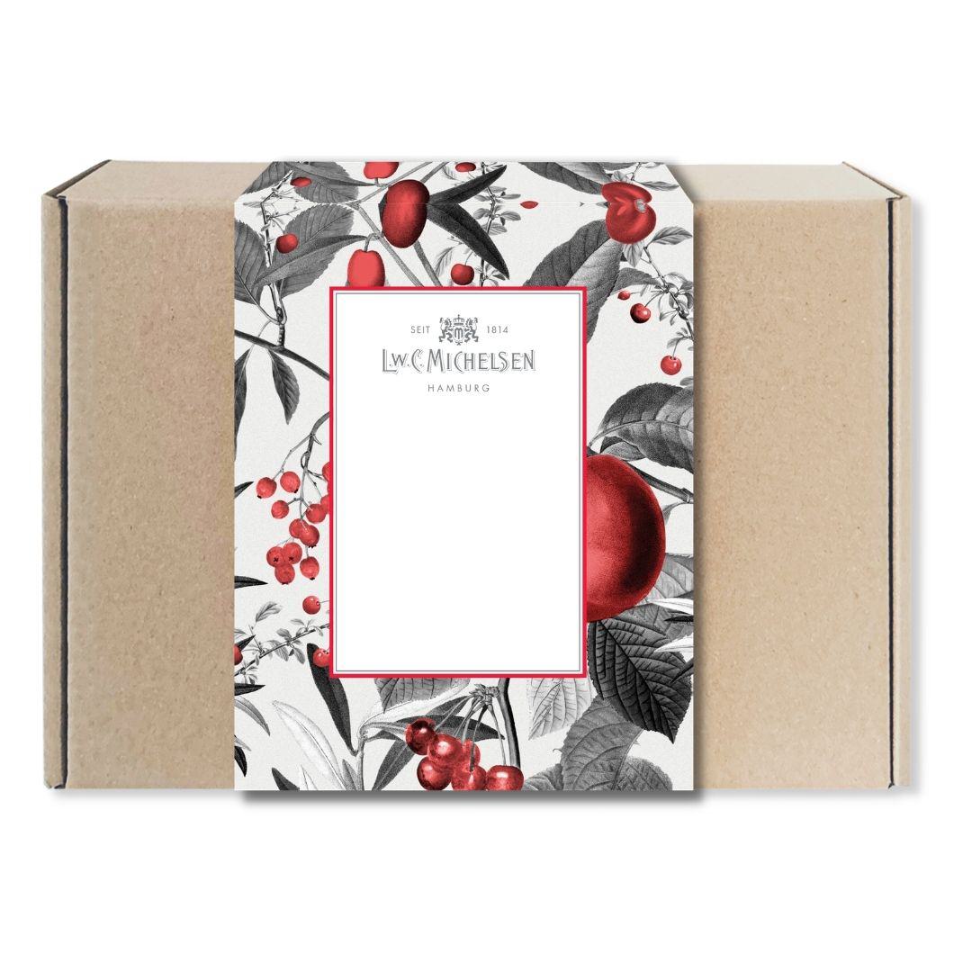 Geschlossene Geschenkbox aus braunem Karton mit Banderole im floralen Design mit roten Früchten und Blättern sowie Logo von L.W.C. Michelsen Hamburg.