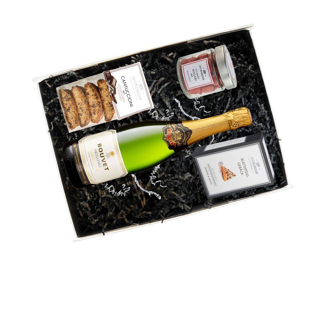 Geöffnete Geschenkbox mit Bouvet Excellence Crémant, Cantuccioni, Wasabi Red und Blätterteiggebäck