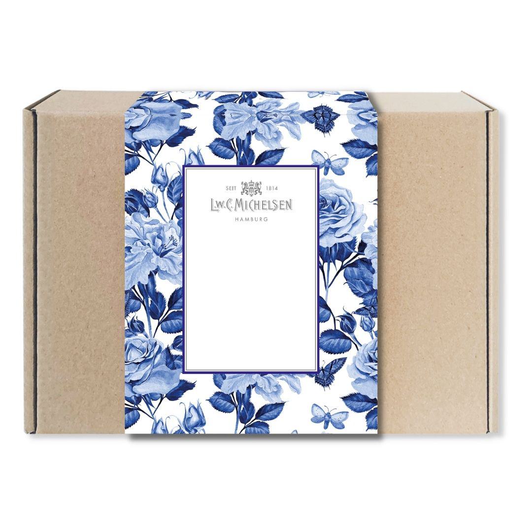 Geschlossene Geschenkbox aus braunem Karton mit Banderole im blauen floralen Design mit Rosen und Schmetterlingen sowie Logo von L.W.C. Michelsen Hamburg