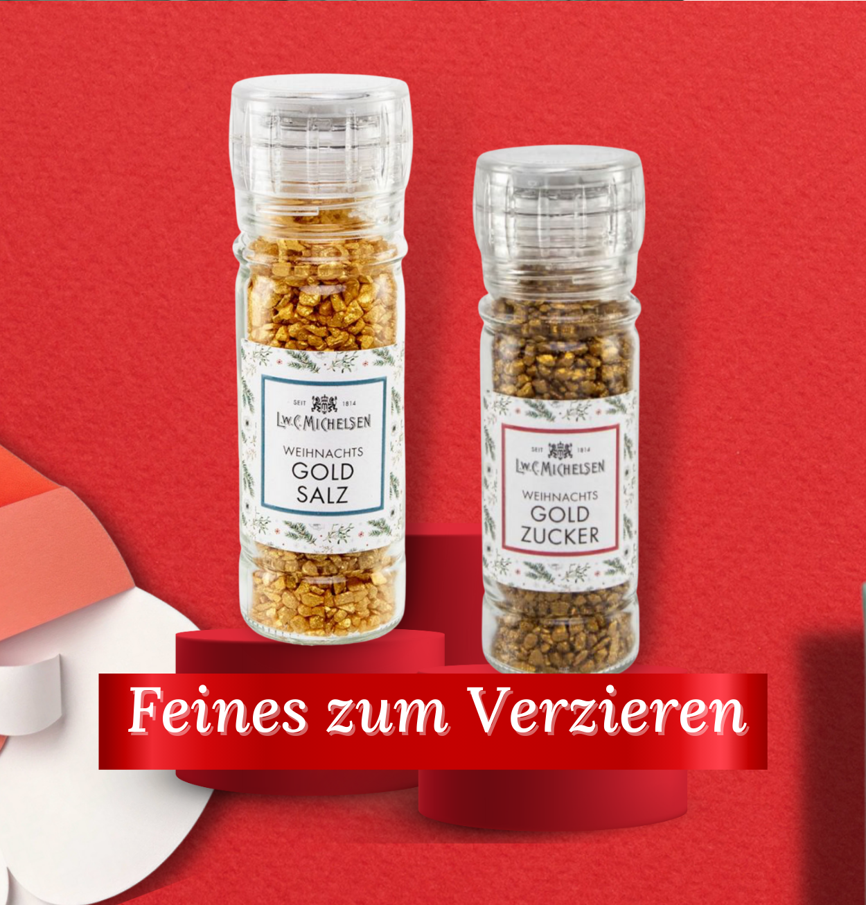 Zwei Gewürzstreuer mit Weihnachts-Gold-Salz und Gold-Zucker auf rotem Hintergrund, Dekoration für festliche Anlässe