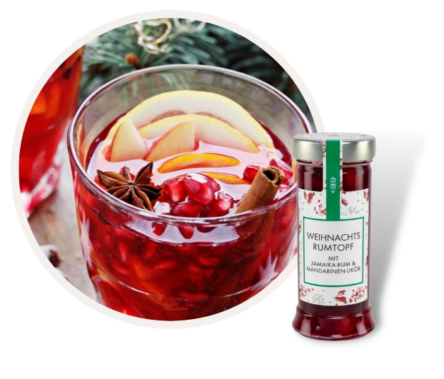 Nahaufnahme eines Glases mit Weihnachts-Rumtopf, Anisstern und Zimtstange, daneben eine Flasche mit der Aufschrift 'Weihnachts-Rumtopf mit Jamaika-Rum & Mandarinenlikör'