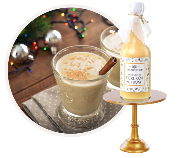 Glas mit weihnachtlichem Eierlikör mit Rum, dekoriert mit Zimt, auf einem Tisch mit Weihnachtsdekoration.