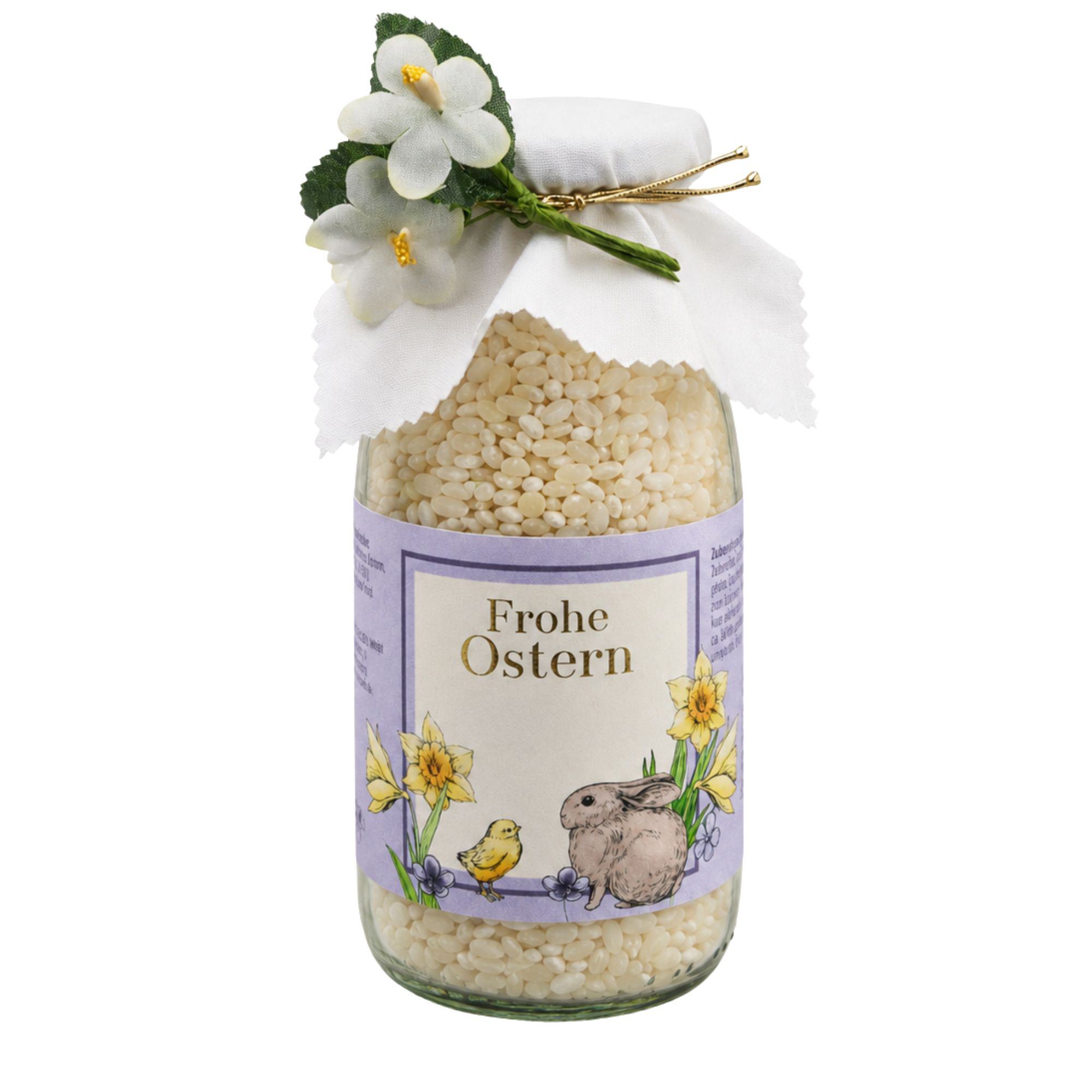 Milchreis „Frohe Ostern" mit Eierlikör im Glas mit weißer Stoffhaube und Frühlingsblumen-Dekoration