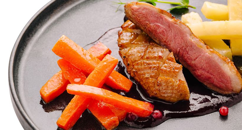 Krosses Entenbrustfilet an Orangen-Cranberry-Sauce mit glasierten Möhrchen